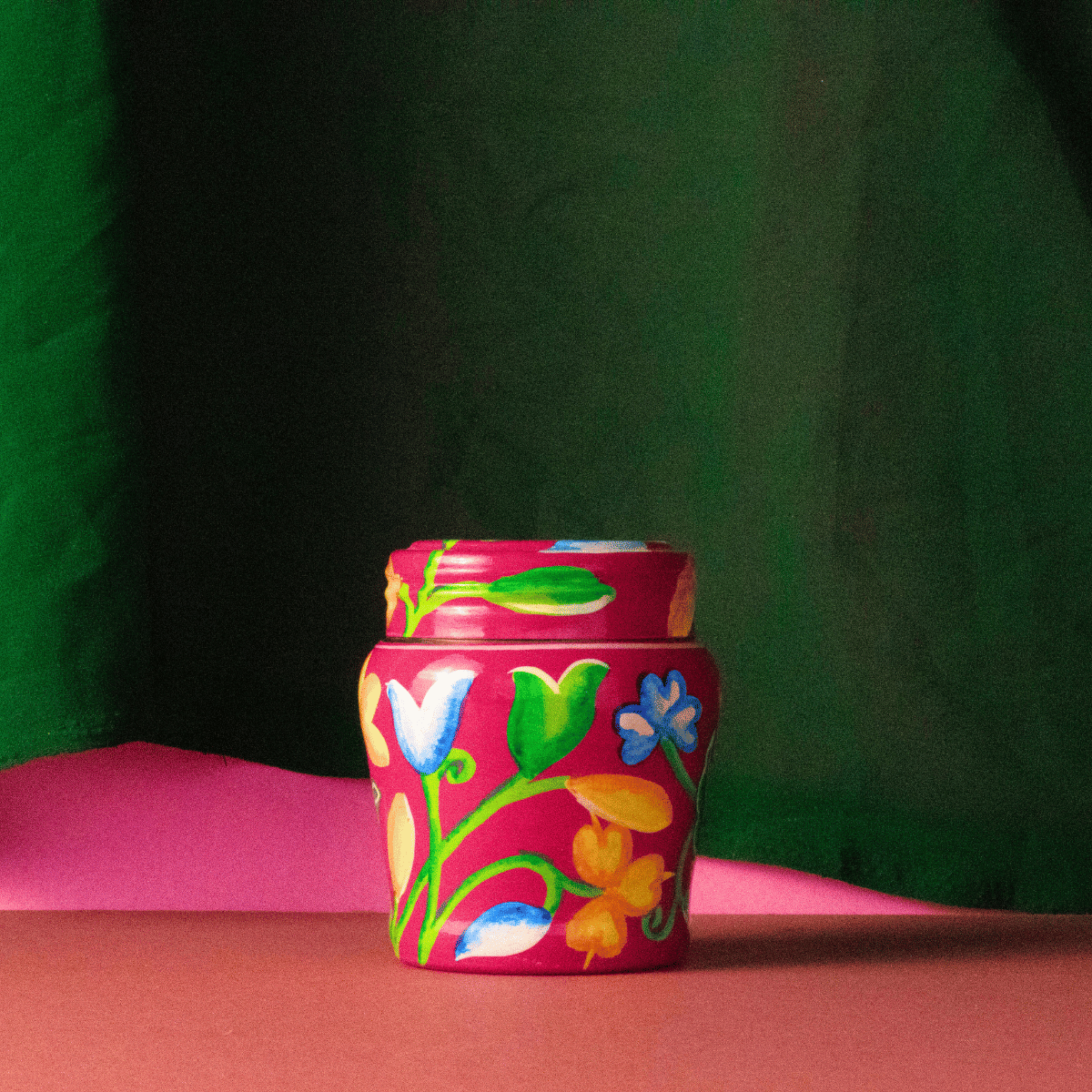 pink body butter jar with green background