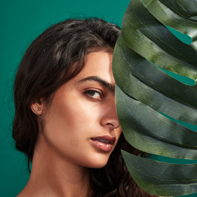 south asian woman hiding behind leaf