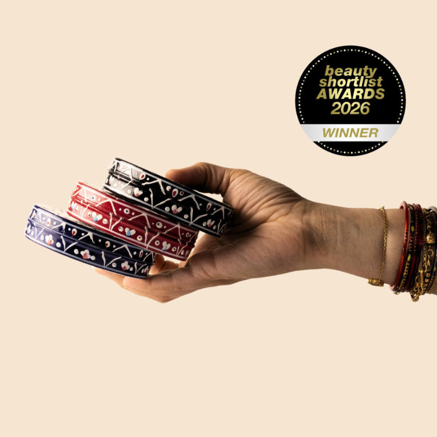 Hand holding three decorative body butter jars with a 'Beauty Shortlist Awards 2026 Winner' badge on a beige background.