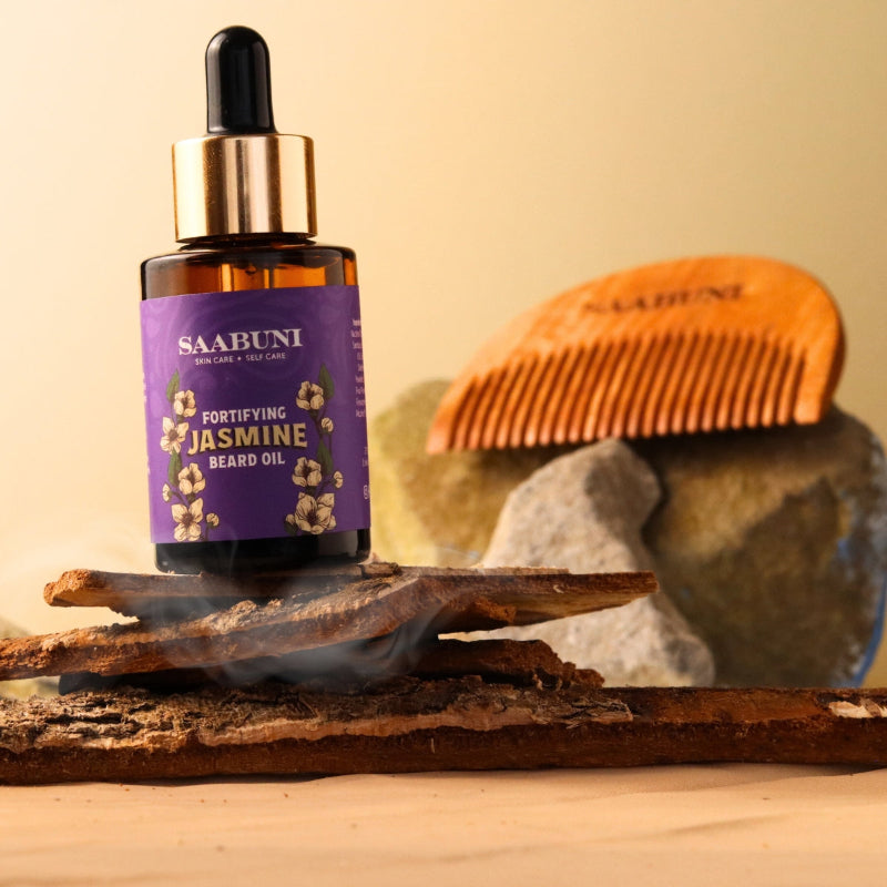 beard oil bottle on top of wood and rocks