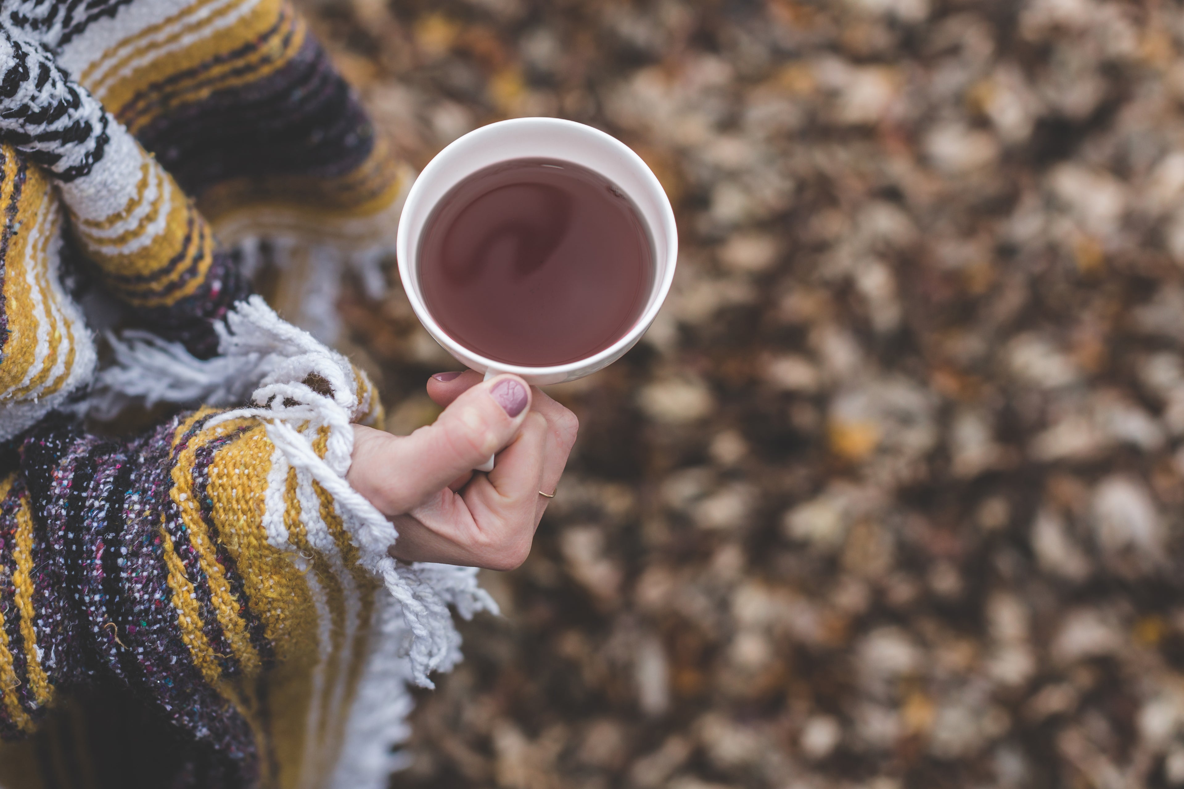 woman holding a cup of tea outside in autumn