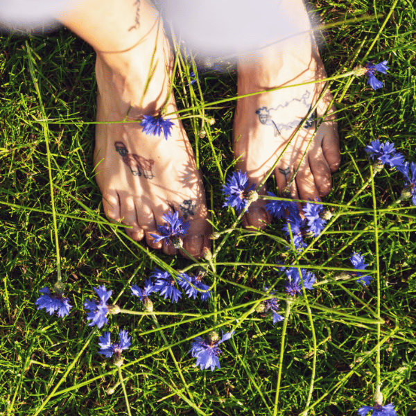 woman walking barefoot on grass