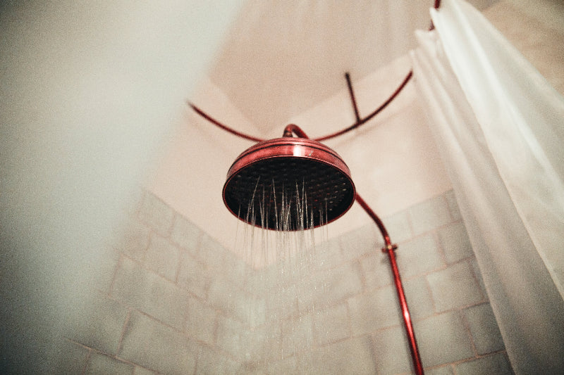 red shower head with water coming out