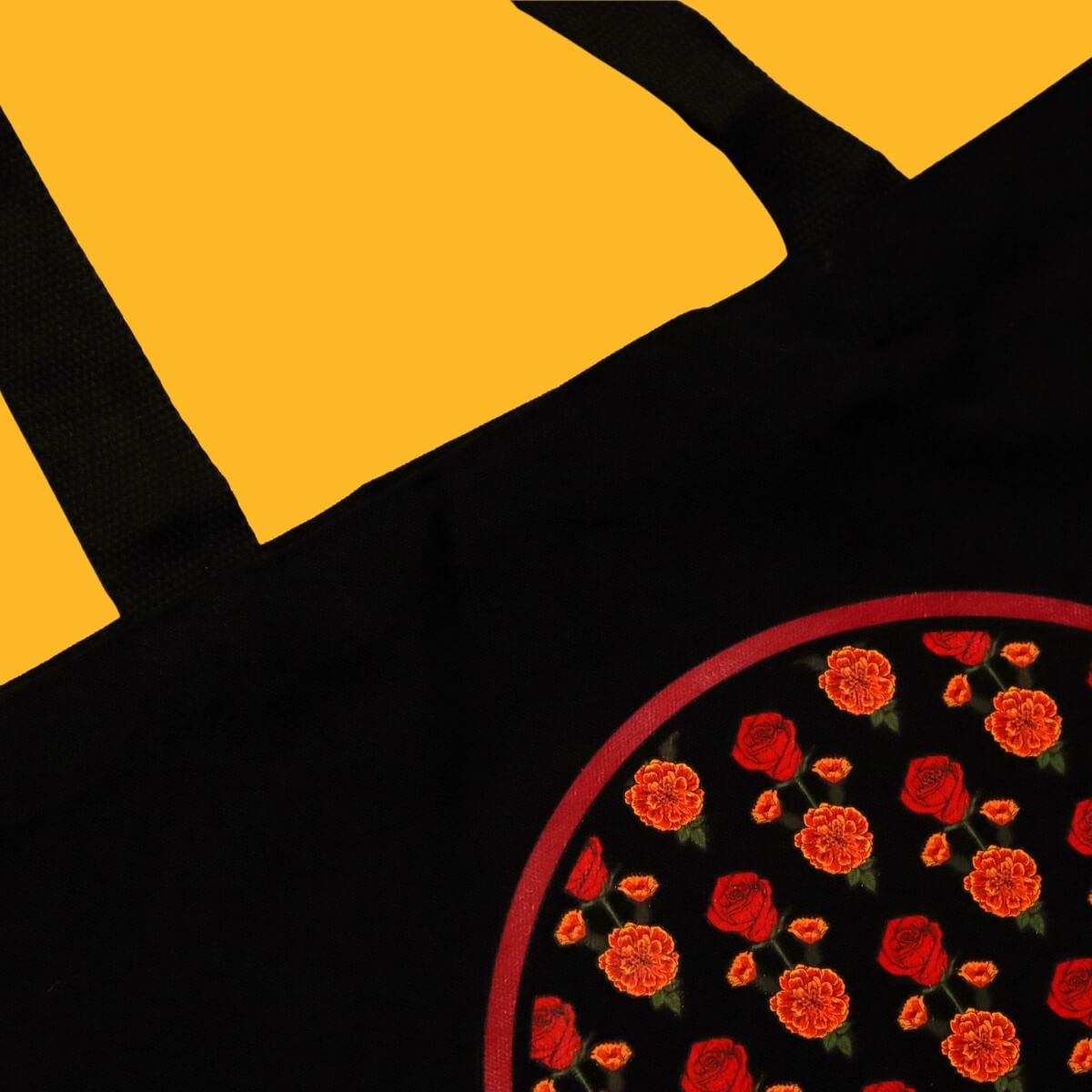 Black tote bag with red flowers on a yellow background