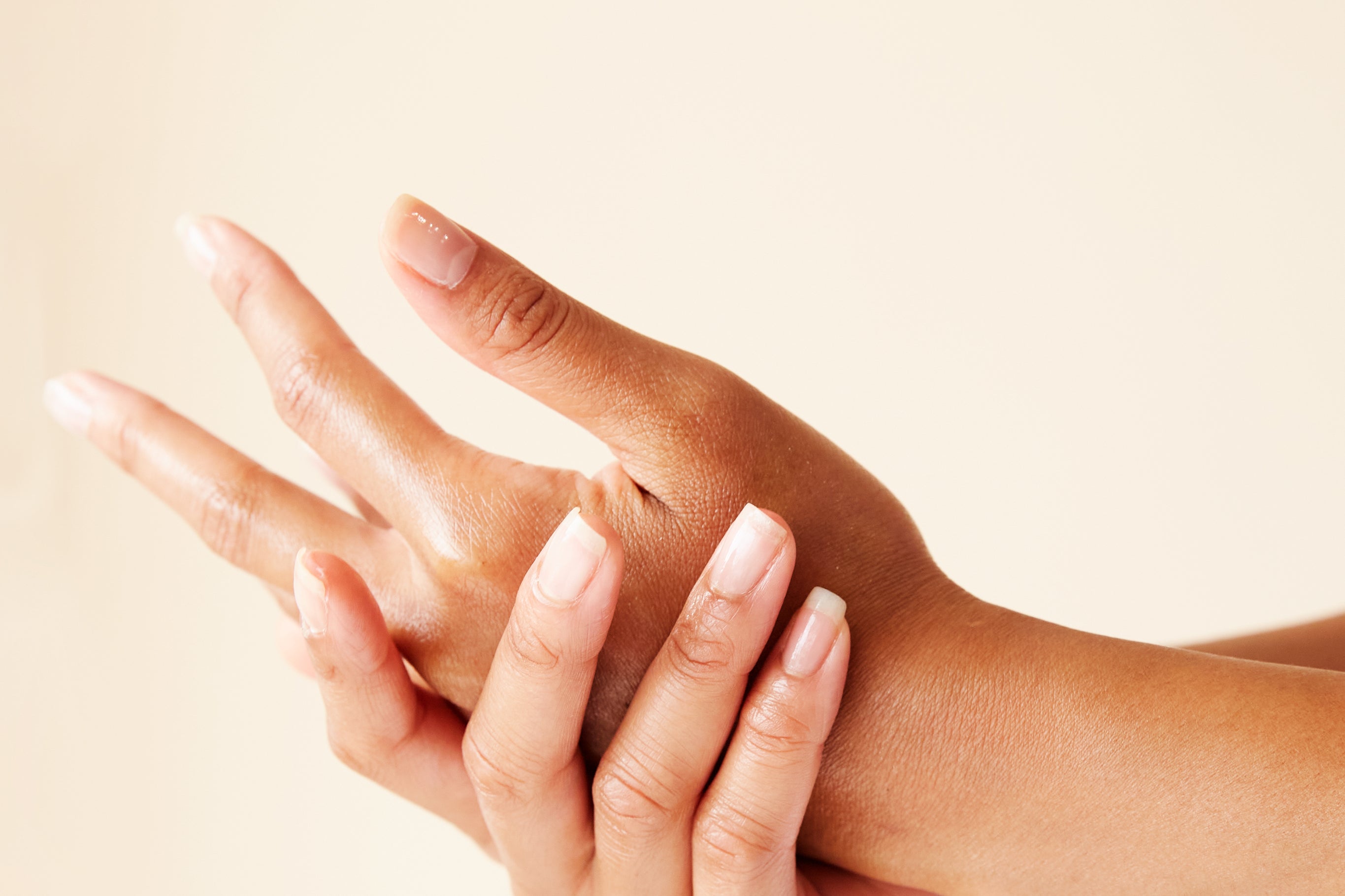 women's hands applying cream